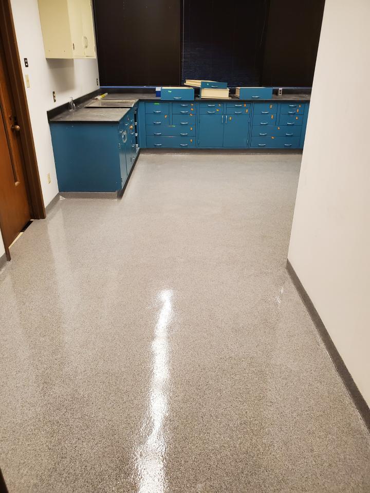 A kitchen with blue cabinets and a shiny floor.