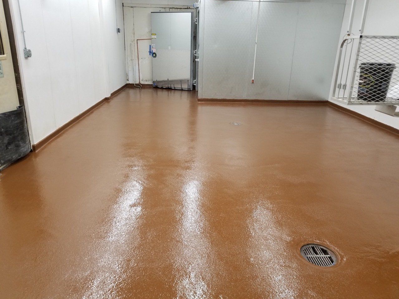 A room with a brown floor and white walls.