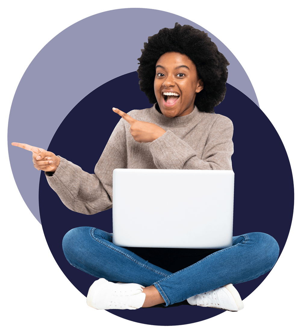 Woman sitting down, smiling, holding laptop on her legs and pointing.