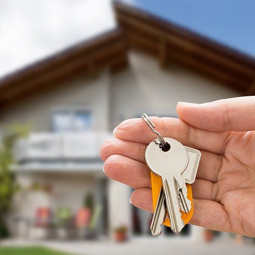 Person Hand Holding House Key — Cape Coral, FL — Ordonez Realty
