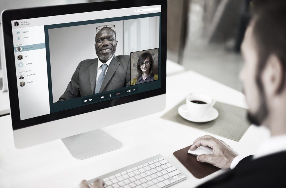 Appel vidéo sur un écran d'ordinateur avec deux participants dans un environnement de bureau lumineux
