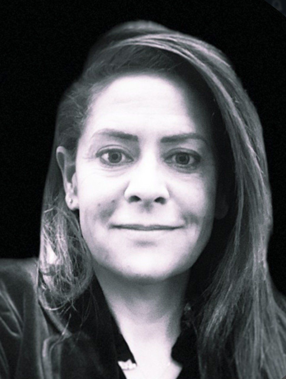 Une femme aux cheveux longs sourit sur une photo en noir et blanc.