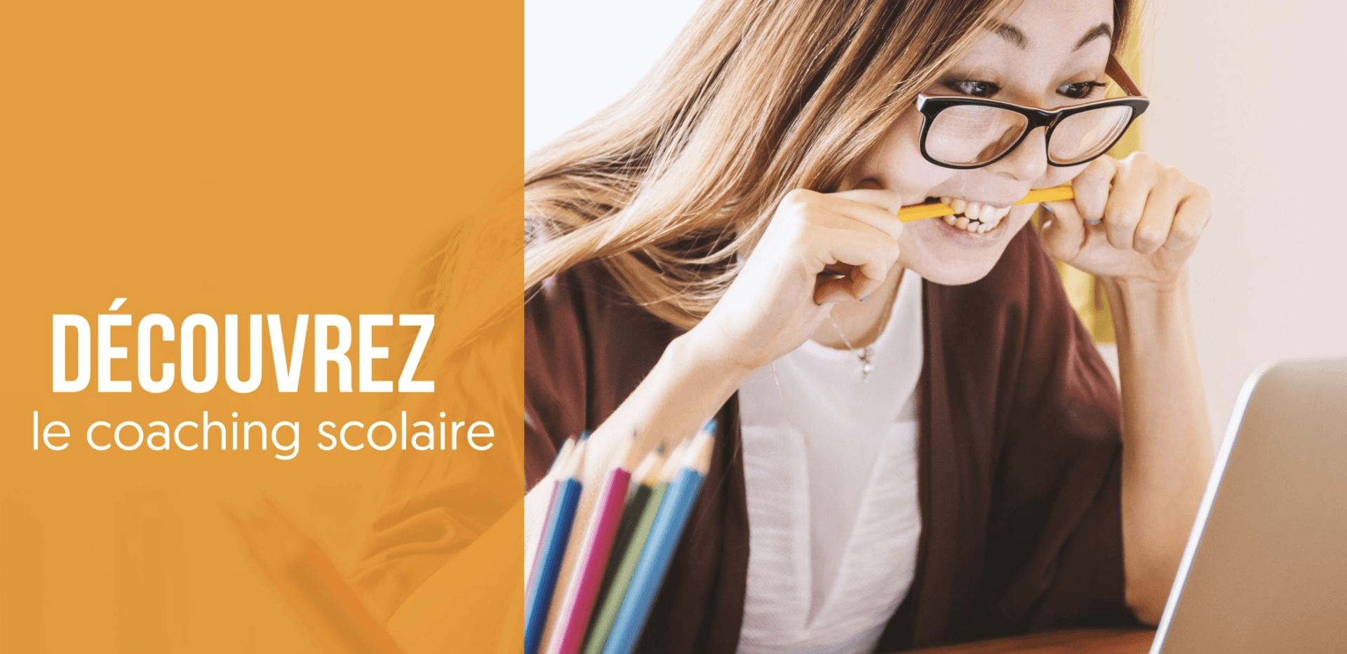 Une femme mord un crayon tout en regardant un ordinateur portable.