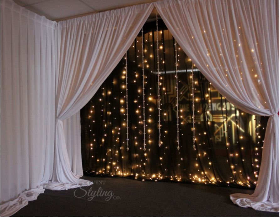 Black fairy light backdrop with white draped front.Hire price from $450 including Auckland installation