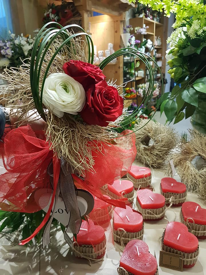 Composizione floreale e candele a forma di cuore