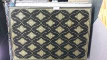 Black and gold patterned decorative panel or box front with repeating diamond motifs