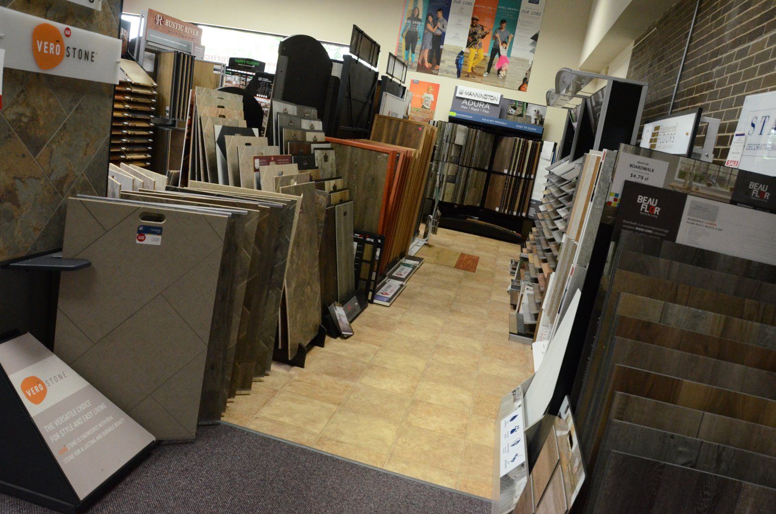 A showroom aisle with large flooring and tile samples displayed on both sides.