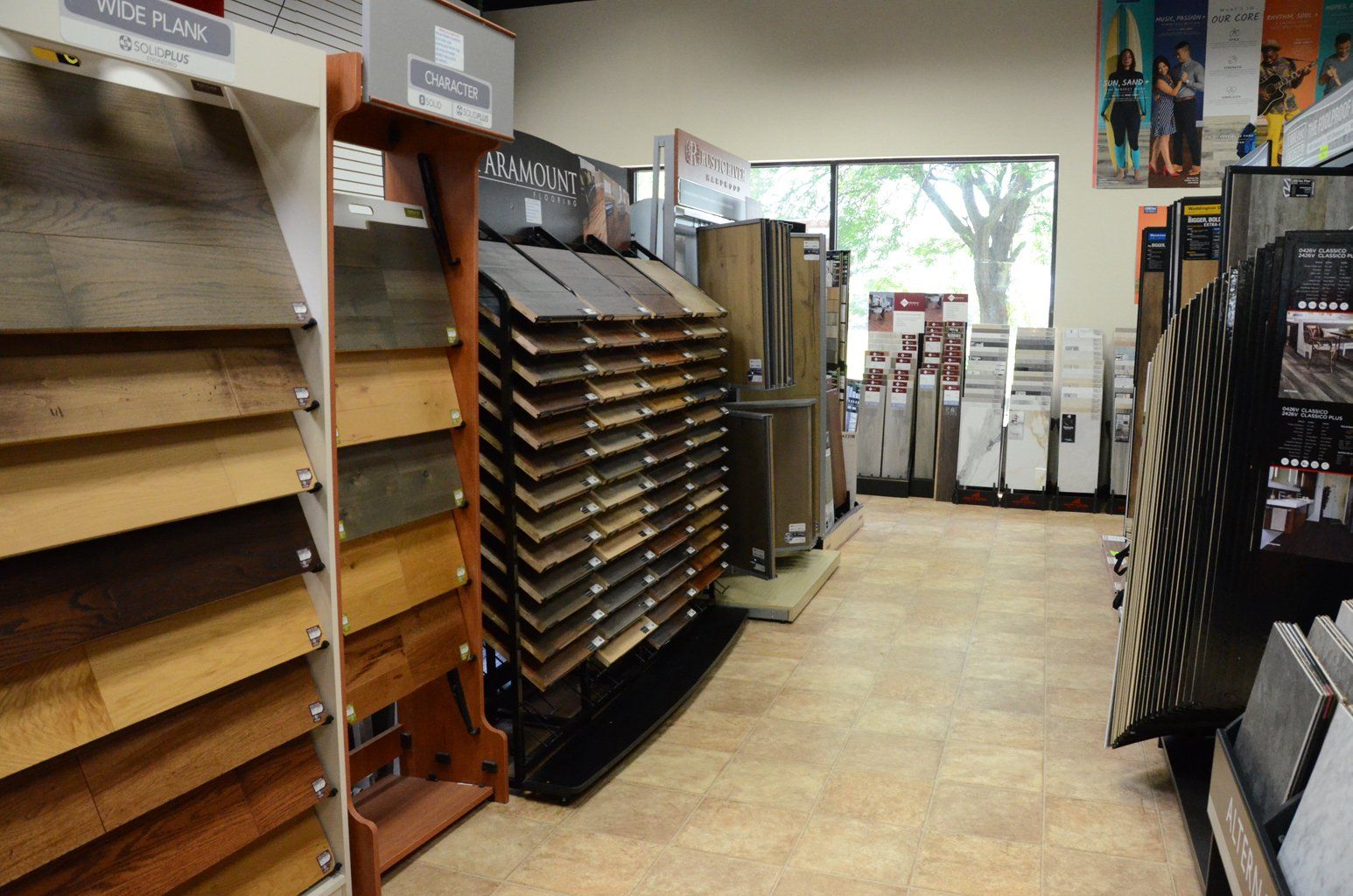 Flooring store aisle with sample display racks and a bright entrance in the background