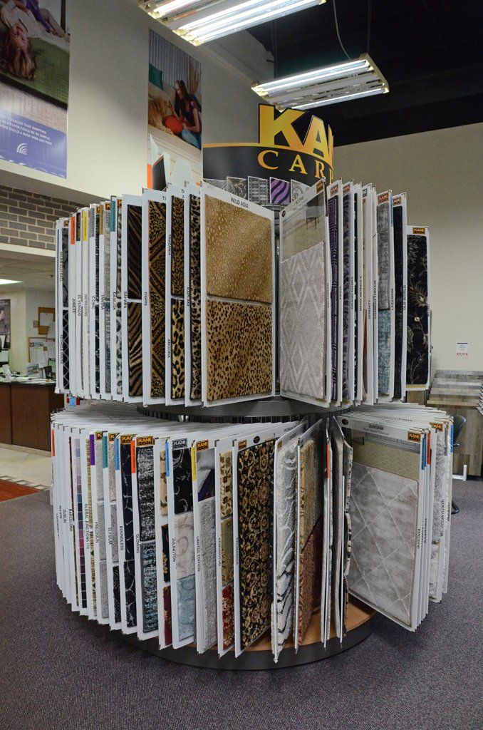Circular magazine display rack in a store with assorted magazines and brochures.