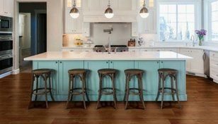 Bright modern kitchen with aqua island, five stools, pendant lights, and large windows