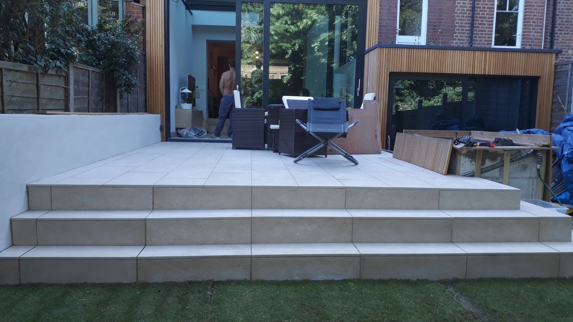 A patio with stairs and a chair in front of a house.