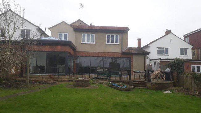 The back of a house with a large lawn in front of it.