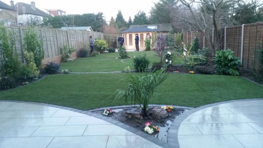 A lush green backyard with a patio and a fence