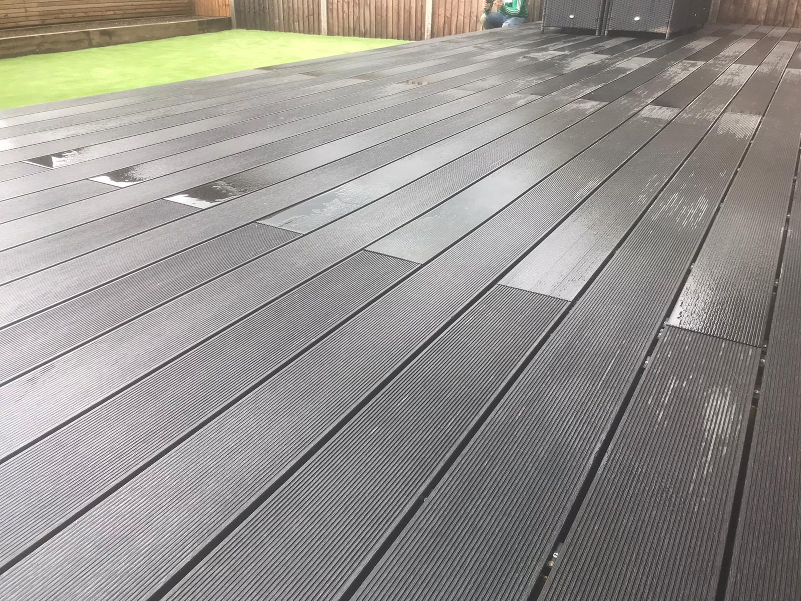 A close up of a wooden deck in a backyard.