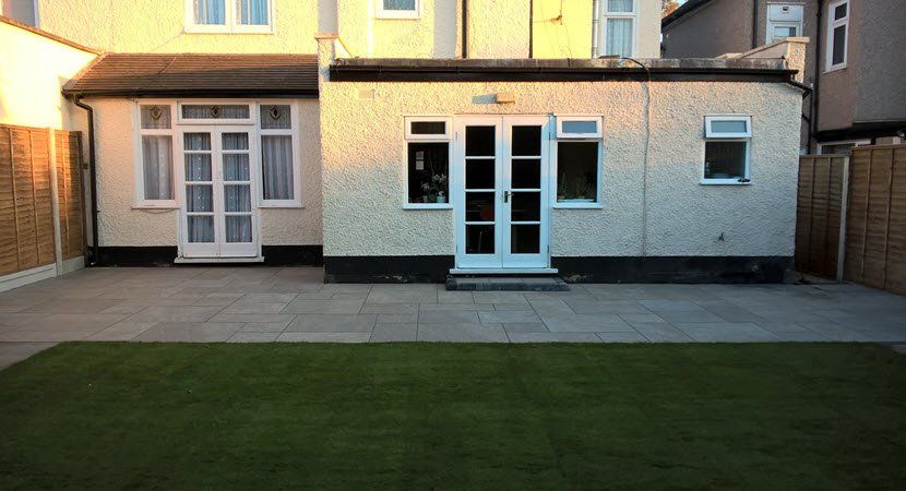 A house with a patio and a lawn in front of it