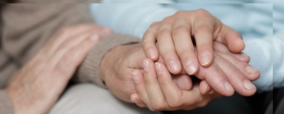 mani di operatore sociosanitario e ospite casa di riposo