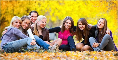 Eine Gruppe junger Frauen sitzt in einem Park auf dem Boden.