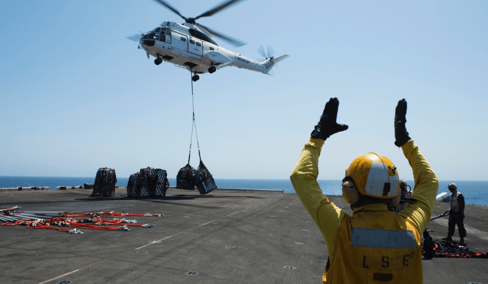 Someone signalling a helicopter to drop off a package