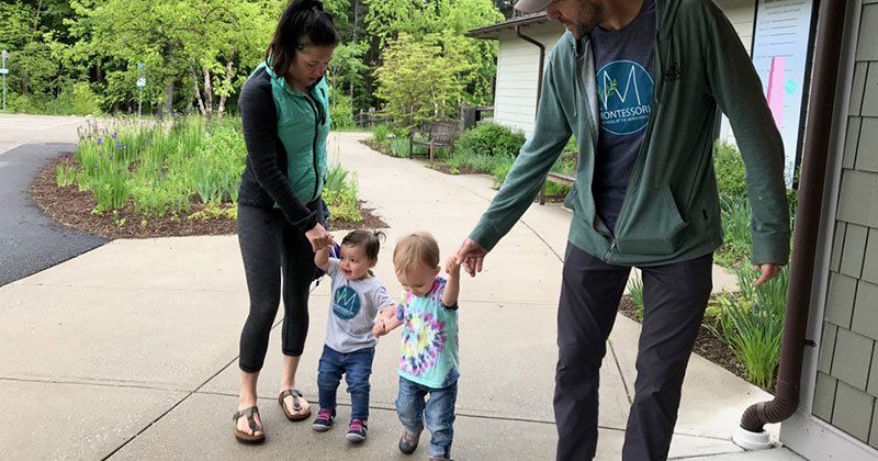 Two parents walking with their toddler children