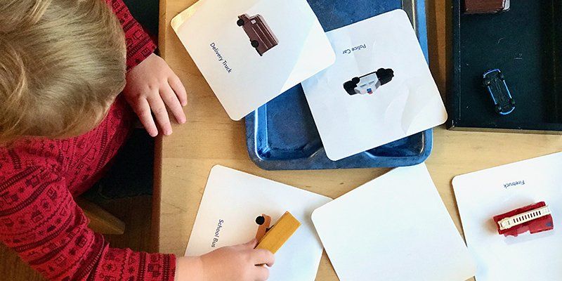 toddler aged child matching vehicles to labeled cards