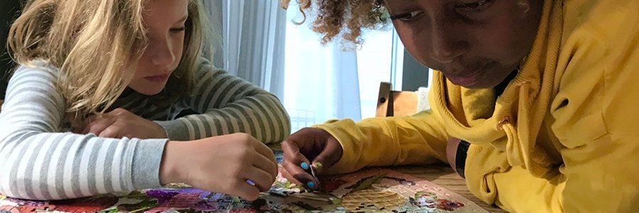 two elementary aged children working on a puzzle together