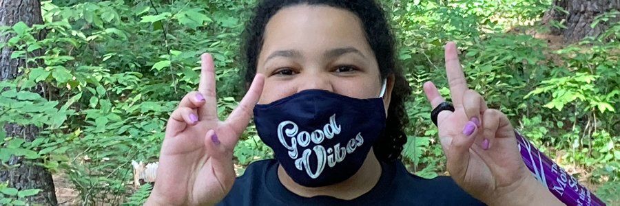 Adolescent student in a mask that reads