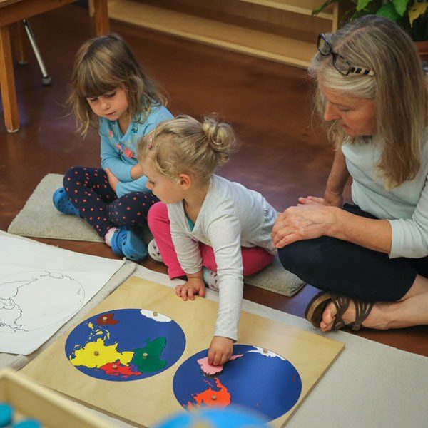 Two children and guide with continents map