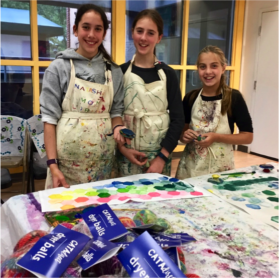 Adolescent students painting fabric