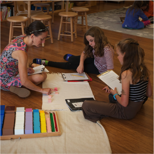 Elementary children with guide and lesson on floor