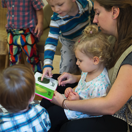Toddlers reading with guide