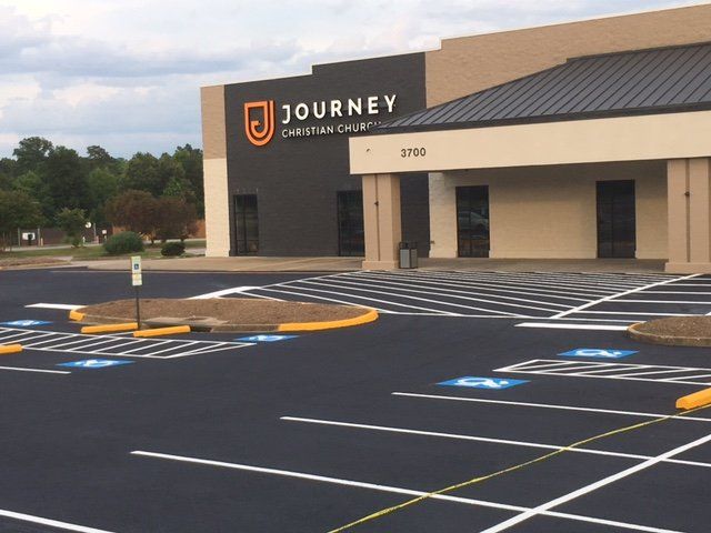 The exterior of Journey Christian Church with a parking lot featuring painted handicap accessible spaces.