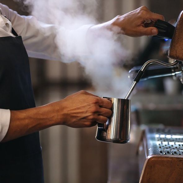 Barista Making a Cup of Coffee in Machine — Cadillac, MI — All Beans Coffee Company Espresso Machine Filling Two Cups of Coffee — Cadillac, MI — All Beans Coffee Company