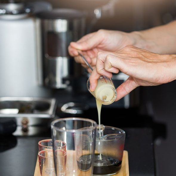 Barista Pouring Milk in a Measuring Cup — Cadillac, MI — All Beans Coffee Company Barista Pouring Milk in a Measuring Cup — Cadillac, MI — All Beans Coffee Company