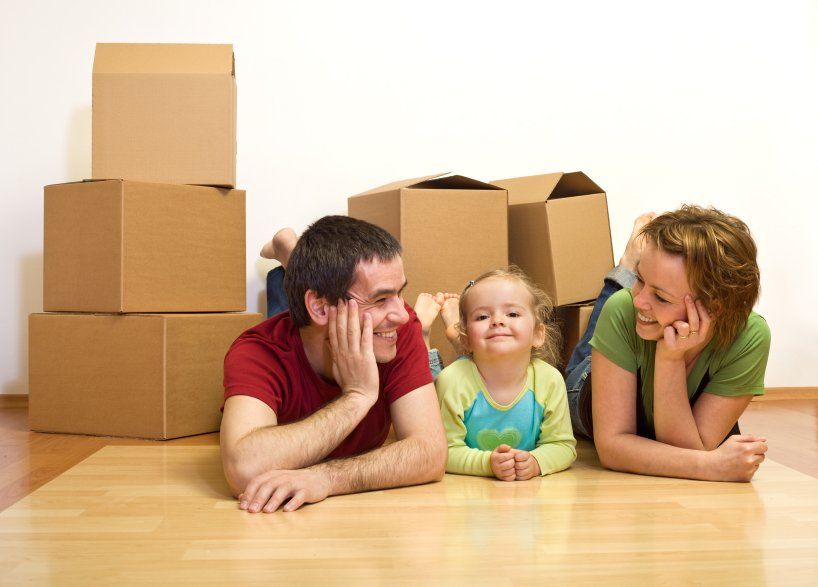 Happy couple with a kid in their new home