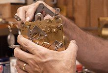 Full-Service Clock Shop — Worker Disassembling Clock in Wayland, MA Full-Service Clock Shop — Worker Disassembling Clock in Wayland, MA