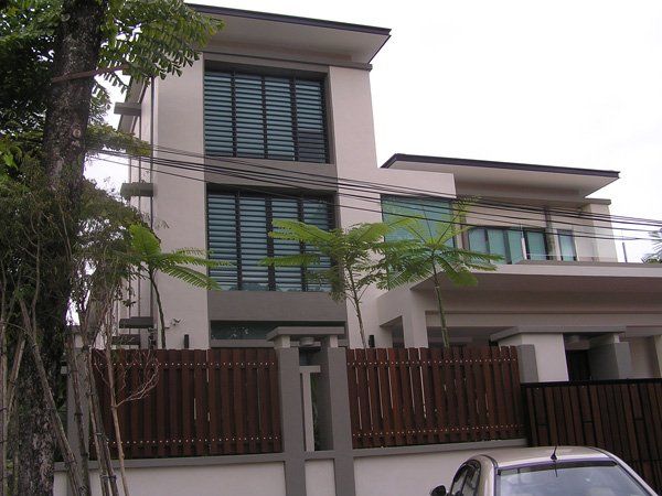 A car is parked in front of a large house