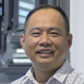 A man in a white shirt is smiling for the camera.