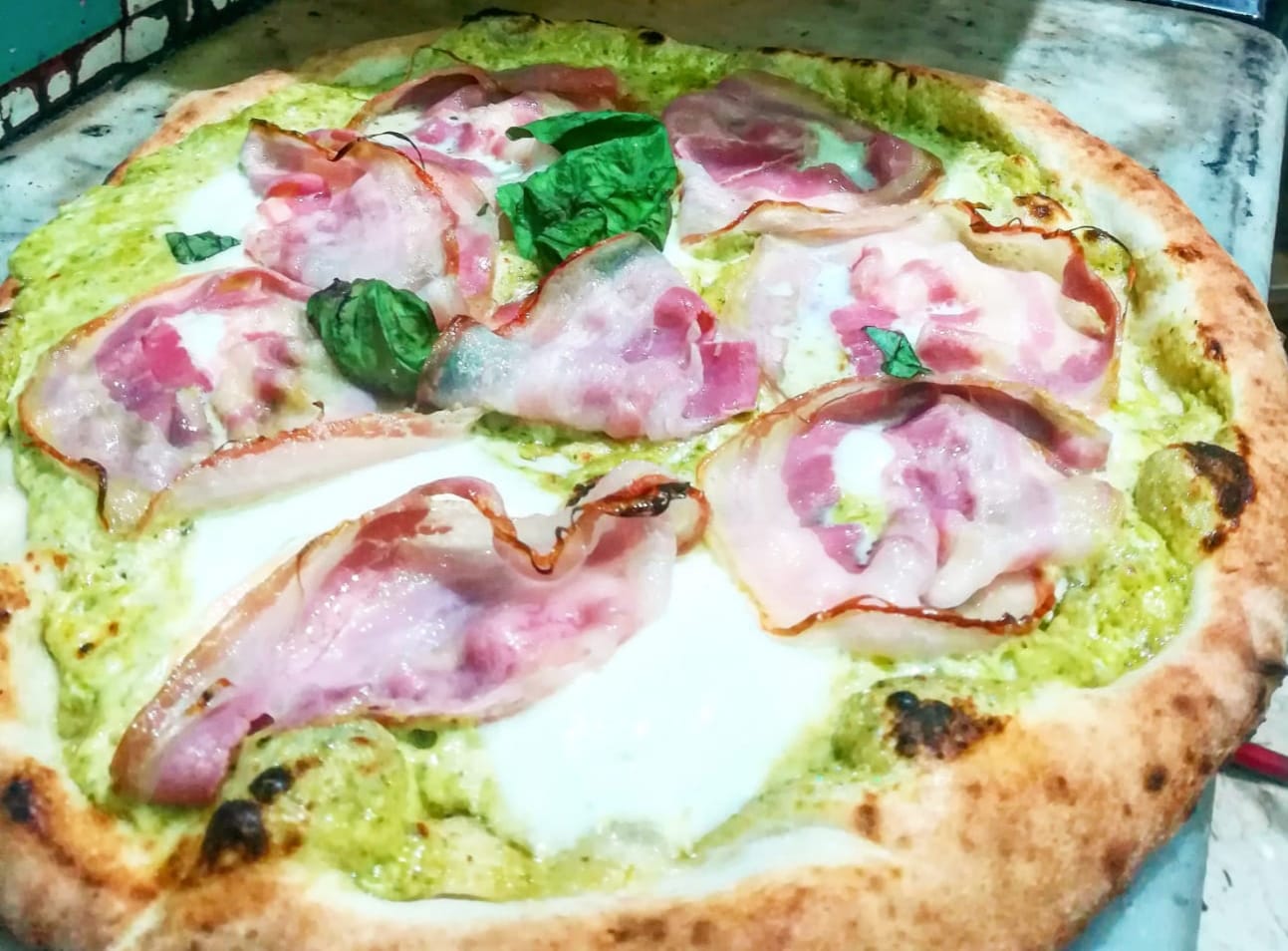 Pizza con pancetta e pesto