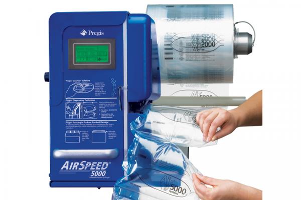 A person is holding a bag in front of a machine that says airspeed 5000.