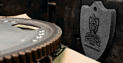 A close up of a gear and a shield on a table.