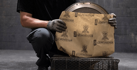 A man is kneeling down holding a piece of paper.