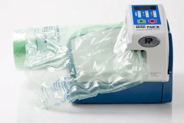 A machine with a green bag on top of it.