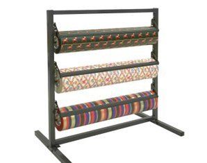 A wrapping paper rack with four rolls of wrapping paper on it.