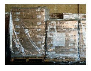 A warehouse filled with lots of boxes wrapped in plastic.