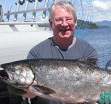 A man is holding a large fish in his hands.