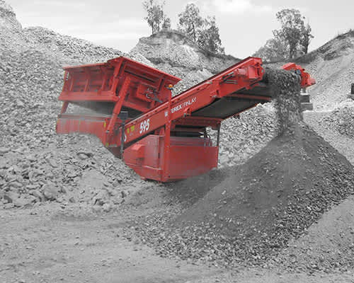 Una máquina roja está sentada encima de una pila de rocas.