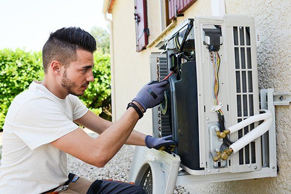 Electrician Installing Air Conditioning — Boise, ID — Northwest Heating & Air Conditioning Inc Electrician Installing Air Conditioning — Boise, ID — Northwest Heating & Air Conditioning Inc