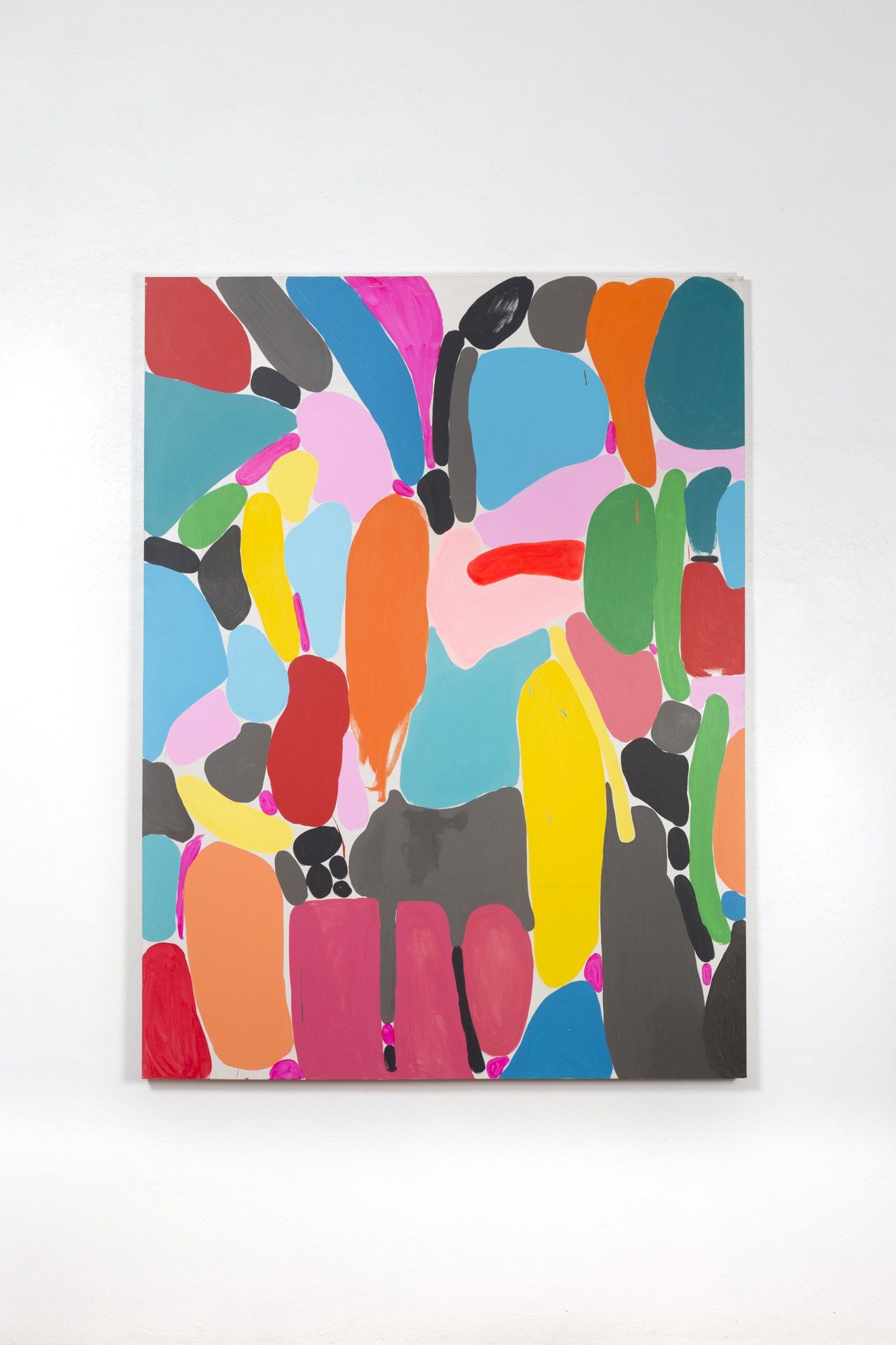 A colorful painting is hanging on a white wall.