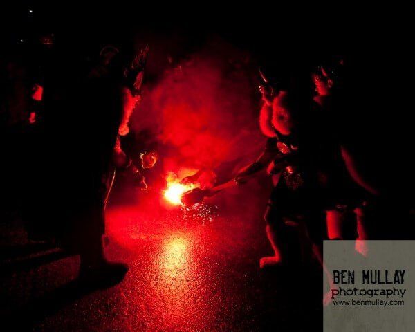 A group of people are standing around a red light that says ben mullaf photography