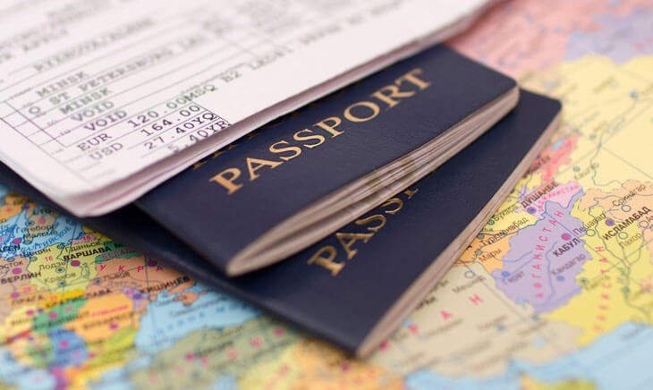 Three passports are stacked on top of each other on a map.